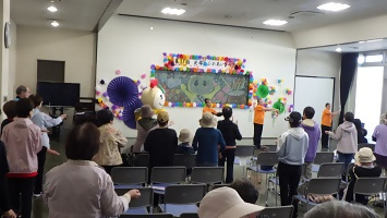 会場のみなさんと一緒に体操をするかまたんの写真