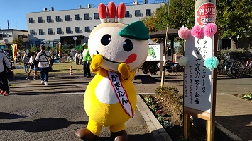 ウクレレを弾く歯医者さんと踊るかまたん、見ている参加者のみなさんの写真