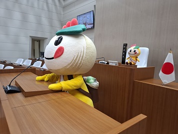 マイクに向かって何か喋ろうとするかまたんの写真