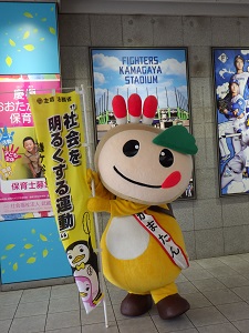 「社会を明るくする運動」ののぼりを持つかまたんの写真