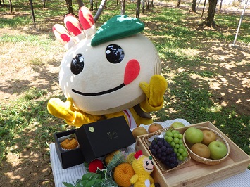 テーブルに乗った梨、ぶどうを目の前に喜ぶかまたんの写真