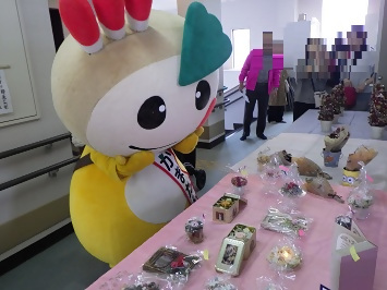 展示作品を見つめるかまたんの写真