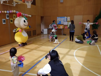 ポンポンを持って踊るかまたんの写真