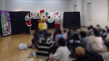 読み聞かせ会に登場したサンタさんとかまたんの写真