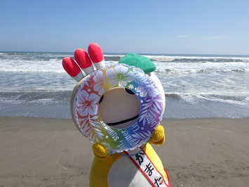 うきわを手に持ち穴から覗き込むかまたんの写真