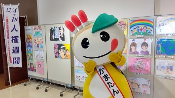 ポスター作品前にて、かまたんの写真