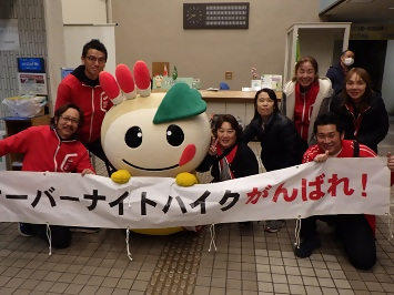 「オーバーナイトハイクがんばれ！」の横断幕を持って応援している、スタッフのみなさんとかまたんの写真