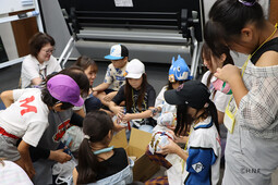 新聞紙を使ってボールを作成している様子（写真）