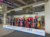マスコットキャラクターと事業に参画する構成団体代表者が出発式セレモニーにてテープカットをしている写真