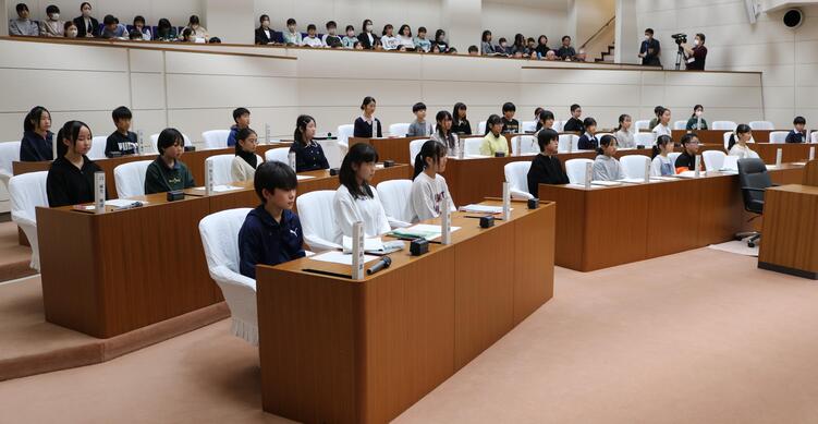 緊張気味の面持ちの議場の小学生議員たちの写真