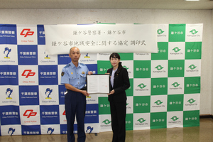 調印式で協定書を取り交わす掛谷鎌ケ谷警察署長（左）と芝田市長（写真）